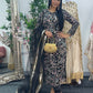 Woman in traditional outfit with floral patterns standing in front of a mirror.
